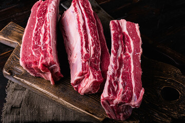 Short Ribs raw beef, on old dark  wooden table background, with copy space for text
