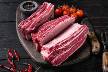 Raw Organic Beef Short Ribs, on black wooden table background