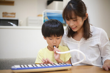 鍵盤ハーモニカの練習をする親子