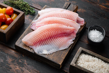 White fish fillet with basmati rice and cherry tomatoes ingredients, on old wooden table - obrazy, fototapety, plakaty