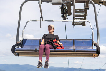 vacation in Carpathian mountains. woman on the lift in the mountains in summer. Ukrainian ski lift...