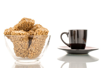 Several sweet roasted candies from sunflower seeds and honey in a glass bowl, macro, isolated on a white background.