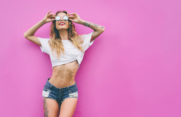 Young woman near pink wall.