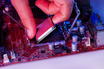 A man's hand inserts a processor into the motherboard chipset