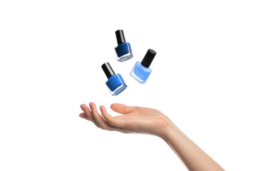 Three shades of blue nail polish bottles levitate, hang over a woman's hand, isolated on white.