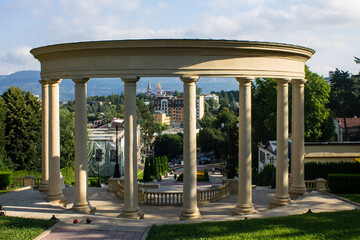 Park landscape - high steps of a cascade staircase and a rotunda with columns among the lush green foliage of trees and bushes in Kislovodsk russia on a summer day