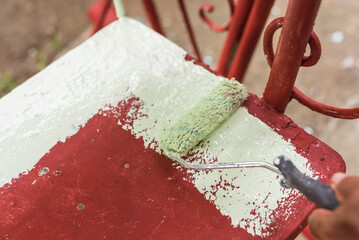 Applying a layer of light green colored quick dry enamel paint on top of another red oxide primer...