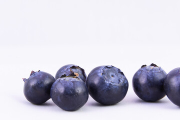 Selective focus, closeup of fresh blueberries against white background