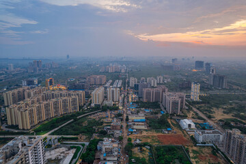 drone aerial shot showing busy traffic filled streets between skyscrapers filled with houses, homes...