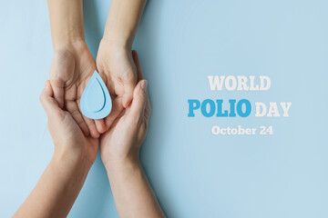World Polio day. October 24. Blue drop in hands of an adult and child is symbol of polio vaccine. Poliomyelitis is disabling and life-threatening disease caused by poliovirus - obrazy, fototapety, plakaty