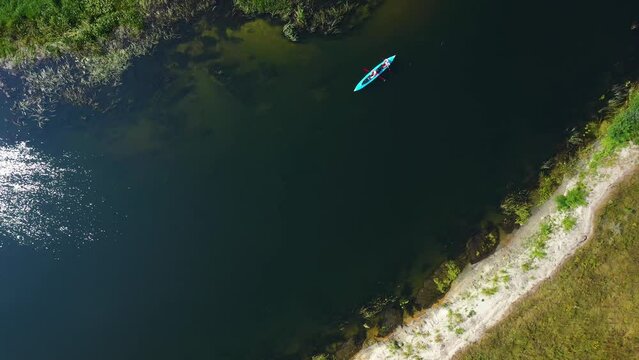 Top aerial view of a group of tourists sailing on a summer river on kayaks. River Seym, Ukraine