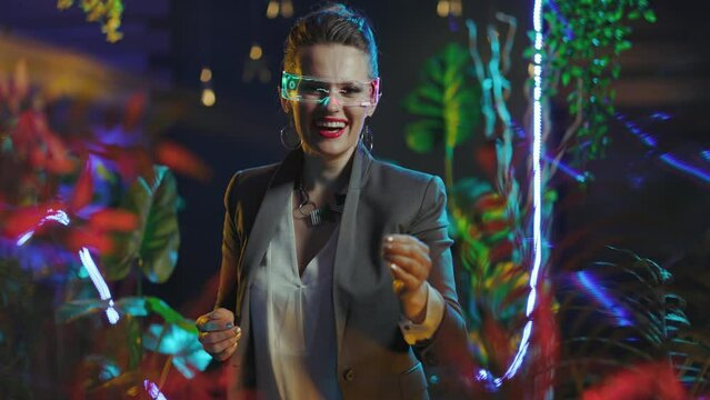happy trendy business woman with futuristic goggles giving hand for a handshake in metaverse.