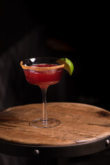 Red cocktail and lime garnish