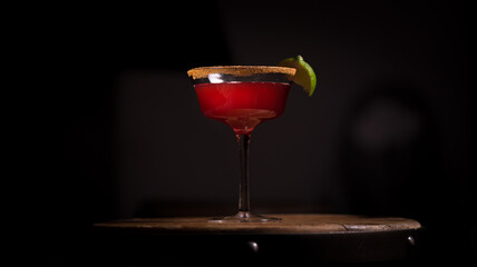 Red cocktail and lime garnish