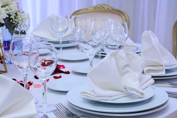 Decorated wedding table with silverware dishes and flower center piece.