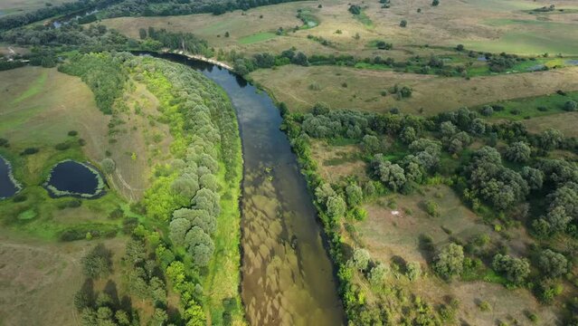 Beautiful aerial view video from a drone of Ukrainian nature - Seim river, summer sunny day on the river with trees and open spaces.