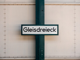 Gleisdreieck name board on the wall of the subway station. Sign with the train station in Berlin, Germany. Architecture of the public transportation in the city. Information at the platform.