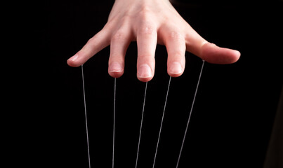 Hand manipulating and controlling smth with strings concept. High quality photo