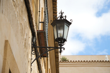 Fototapeta na wymiar Street lamp in a street of a European Mediterranean style city. Seville and one of its central streets. Travel concept