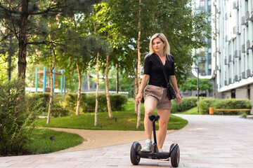 Beautiful woman stand near segway or hoverboard. self balancing electrical scooter.