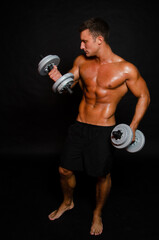 Fototapeta na wymiar Young attractive sportsman with dumbbells. Male athletic body. 