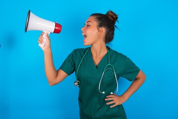 Funny beautiful doctor woman wearing medical uniform over blue background People sincere emotions...