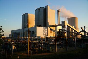 Transformer station in front of a coal power plant, wrapped in the red evening sunlight. Old...