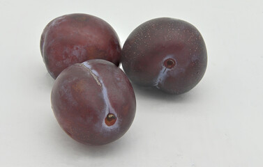 three plum fruits on a white background