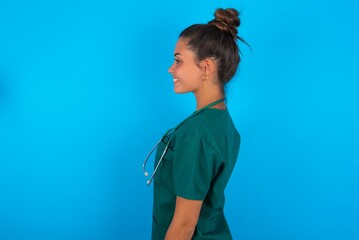 Profile portrait of nice beautiful doctor woman wearing medical uniform over blue background look...