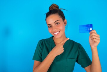 Photo portrait of beautiful doctor woman wearing medical uniform over blue background doing...