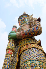 Giant statue standing guard at the Emerald Buddha Temple Ancient Thai architecture and art