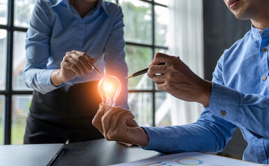 Obraz na płótnie Canvas Businessman's hand holding a light bulb that glows like an idea for work