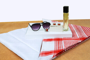 Saudi Arabian men wearing style accessories red white headscarf shemagh sunglasses perfume stone ring cufflinks decorated on wooden sheet