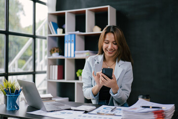 Fototapeta premium Young business women working and typing on laptop with happy and smile face on office spec.