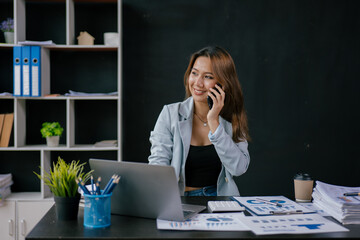 Fototapeta premium Young business women working and typing on laptop with happy and smile face on office spec.