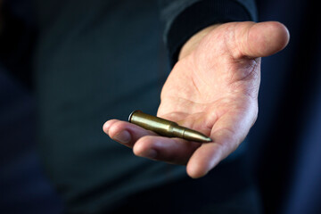 machine gun cartridge in outstretched hand, give weapons, military assistance