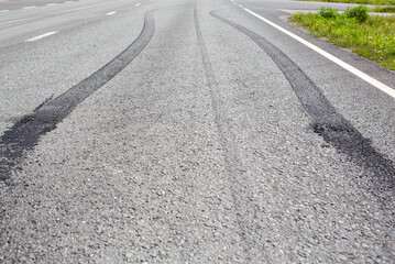 Burnouts on the asphalt made with a powerful muscle car. Skidmark or brake marks due to slippery road or accident. Dangerous driving or accident concept image. - 522838810