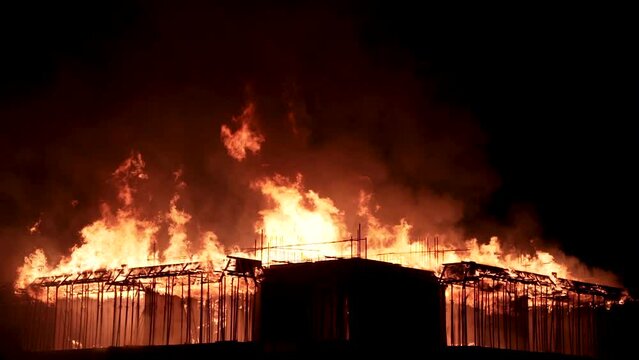 Slow motion burning fire flame on residential building roof at night