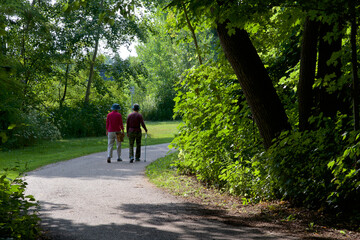 Senior adults walking  in the public park with walking stick