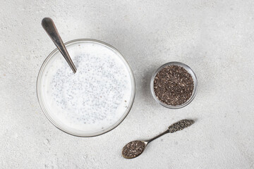 Chia seeds and natural yogurt for making pudding on a gray background, Top view