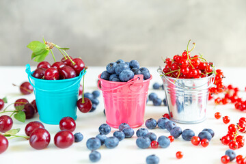 Mix of fresh berries in small buckets.