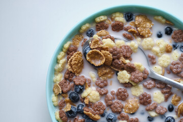 Healthy breakfast in bowls with muesli corn flakes, fresh blueberry milk. The concept of health and diet