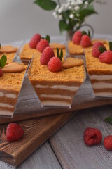 Trifle with raspberries, with a bouquet of flowers and a blurred background.