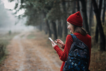 Travel Apps. Young woman traveler with backpack holding smartphone device in hands
