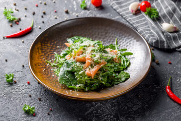 mixed salad with salmon, spinach and aragula on grey table