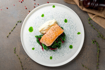 Salmon steak on the grill spinach and mashed selery on plate top view