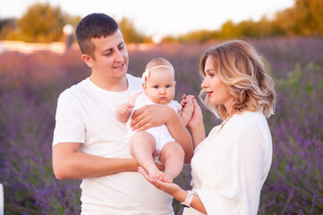 Beautiful young family on purple flower lavender field. Family vacation