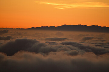 Landscape over the clouds in sunset