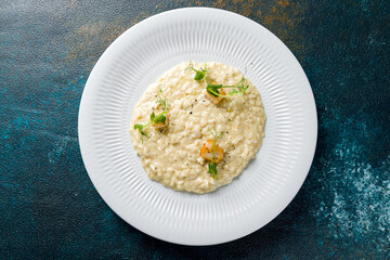 risotto with scallops and truffle oil on white plate top view