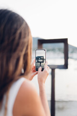Chica tomando una fotografía de postal de Cadaqués, Costa Brava, Cataluña.